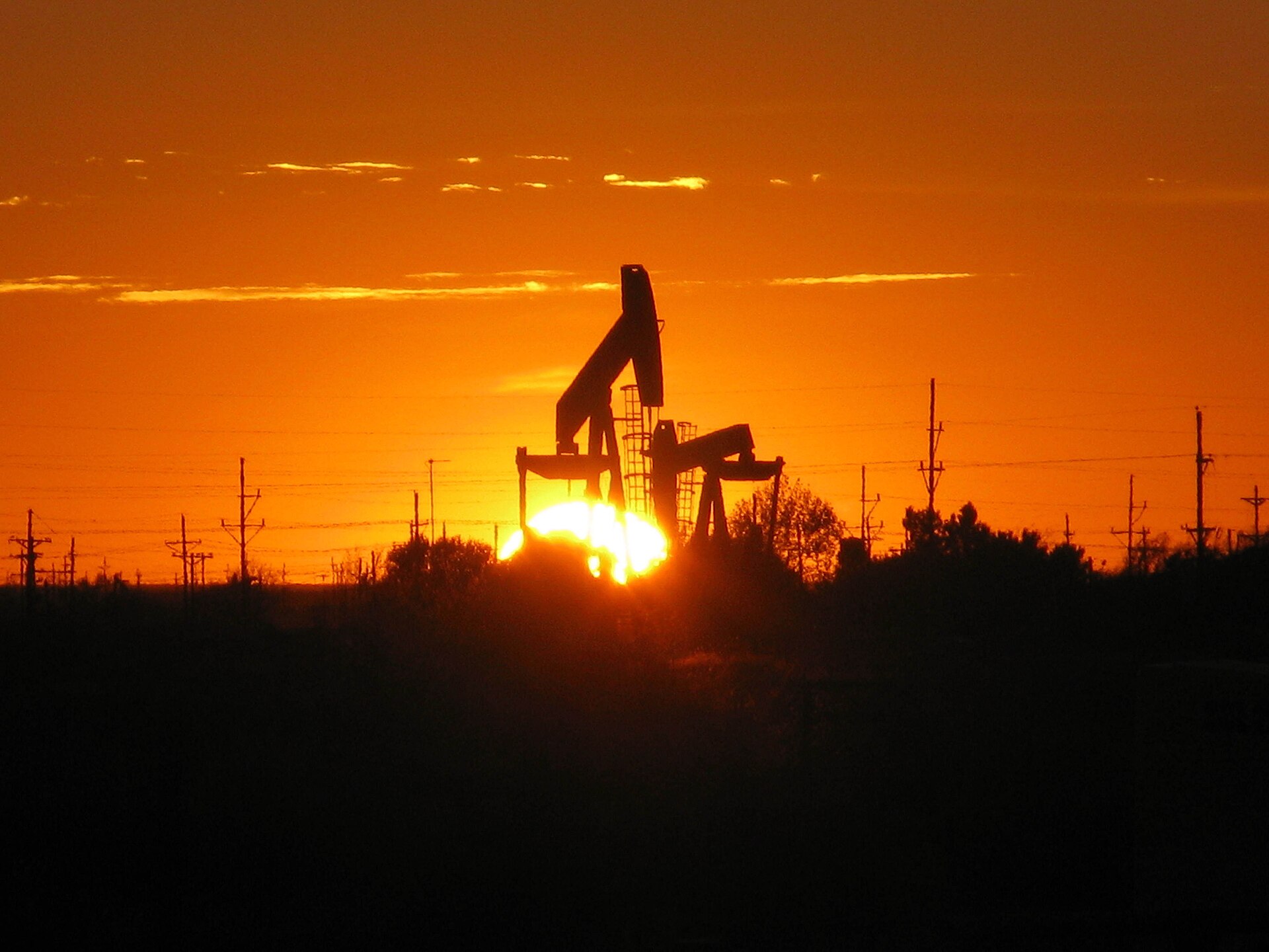 Oil pump jacks silhouetted against a sunset near Midland, Texas